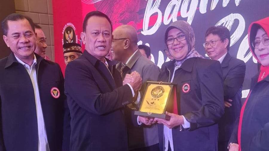Ketua FKPT Jatim Hesti Armiwulan saat menerima penghargaan dari Deputi Bidang Pencegahan, Perlindungan dan Deradikalisasi BNPT RI, Mayjen TNI Nisan Setiadi pada Rakornas FKPT di Sentul Bogor. (Foto: humas fkpt jatim)