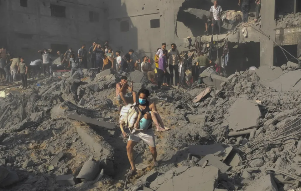 Warga Gaza korban serangan Israel menyelematkan korban dari reruntugan gedung. (Foto: Reuters via Al Jazeera)