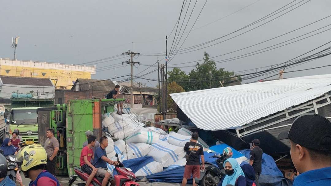 Truk terguling di jalan raya poros nasional Tuban-Lamongan dan menabrak warung. (Foto: Istimewa)