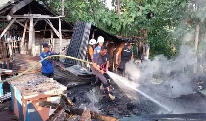 Anggota Damkar Bondowoso berjibaku memadamkan api membakat warung yang tutup seharian. (Foto: Dokumentasi Satpil PP Bondowoso)