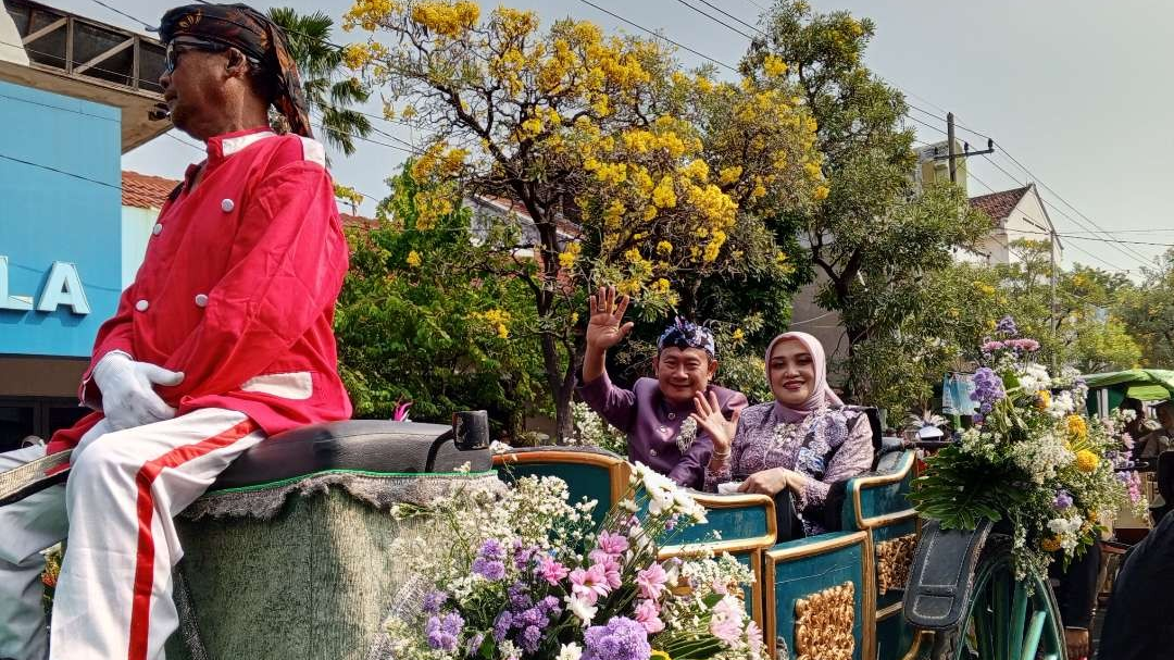 Bupati Lamongan Yuhronur Efendi beserta istri naik kereta kencana pada kirab pataka hari Jadi Lamongan ke-455 (Foto: Imron Rosidi/Ngopibaremg.id)i