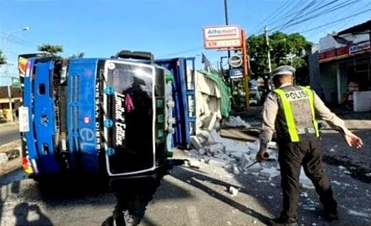 Anggota Satlantas Polres Situbondo mengamankan lokasi kecelakaan truk muat bata putih ringan terguling di Jalur Pantura Situbondo.(Foto: Satlantas Polres Situbondo)