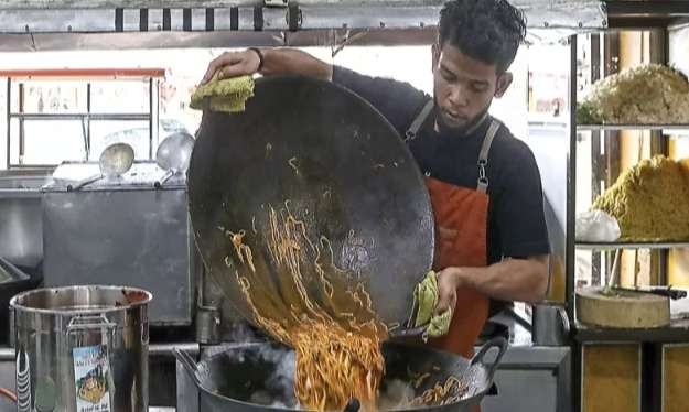 Kesibukan  di kedai nasi goreng dan mie Aceh saat melayani pengunjung, harus menggunakan wajan besar supaya memasak beberapa porsi dalam porsi besar. (Foto: Istimewa)  ayani