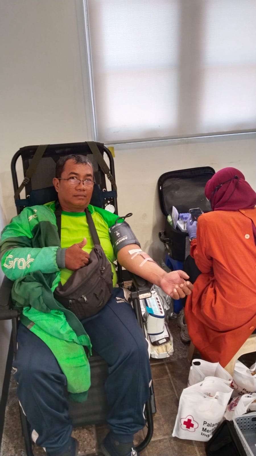 Salah satu pengemudi ojek online, Fakhrul Riza, saat mendonorkan darahnya dalam acara Donor Darah yang diadakan Ngopibareng.id bersama PMI Kota Surabaya. (Foto: Julianus Palermo/Ngopibareng.id)