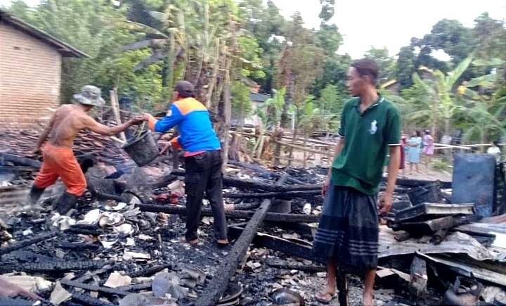Anggota BPBD Situbondo dan sejumlah warga membersihkan puing-puing bangunan rumah warga terbakar di Desa/Kecamatan Suboh. (Foto: Dok. BPBD Situbondo)