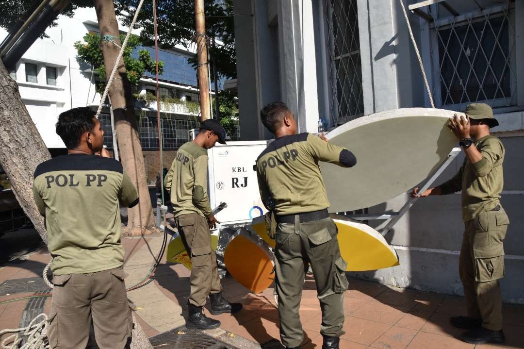 Petugas gabungan Satpol PP dan Bapenda Kota Surabaya saat membongkar reklame di Jalan Rajawali, Surabaya. (Foto: Humas Pemkot Surabaya)