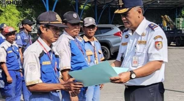 Kepala Dinas Perhubungan Jember Agus Wijaya saat memberikan penghargaan kepada tiga juru parkir atas kinerjanya yang cukup baik (Foto: Dok Dishub Jember)