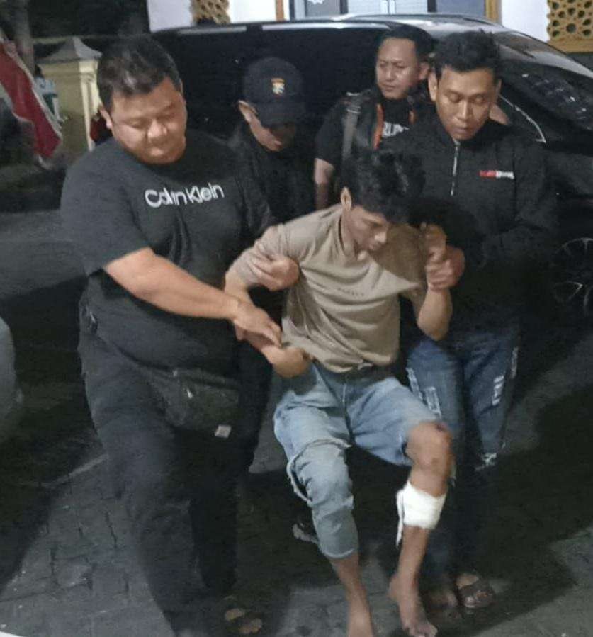 Tersangka pencurian kendaraan bermotor, Muafi ketika digotong petugas Polsek Sukolilo, setelah kaki kirinya ditembak aparat kepolisian. (Foto: Istimewa)