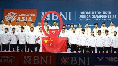 Zhang Qi (dilingkari kanan) pelatih tunggal putra tim bulu tangkis China membawa jersey milik Zhang Zhi Jie berwarna merah ke podium. Trofi juara diterima pemain tunggal putra Hu Zhe An. (Foto: Istimewa)